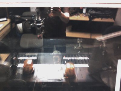 Foto im Inneren des Studio 1 beim FRK, in der Scheibe spiegeln sich DJ sowie Studioinneres